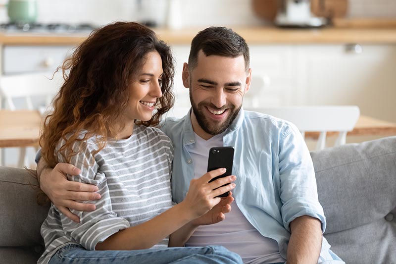 Couple viewing their home inspection report on a smartphone 